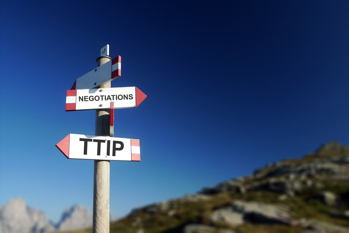 TTIP agreement written on mountain signpost in two directions. Negotiations at the top of the agenda concept.